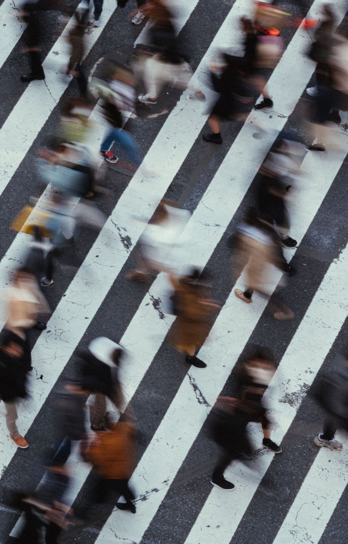 Commuters blurring across a crosswalk from above